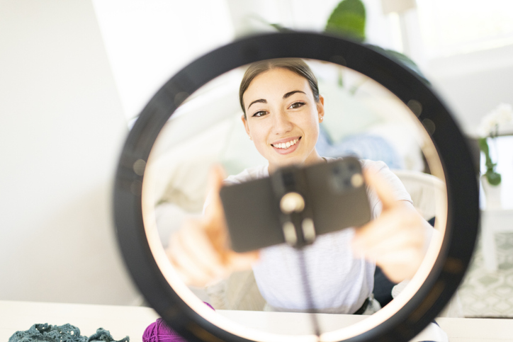 Woman setting angle of phone with ring light